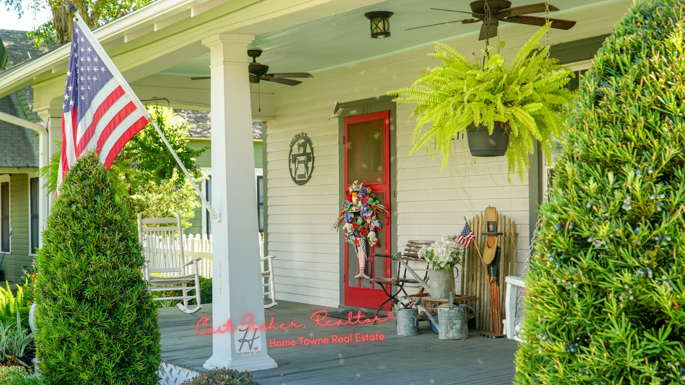 PHOTO OF AN AMERICAN HOME WITH AN AMERICAN FLAG. CAIT FISHER, REALTOR | HOME TOWNE REAL ESTATE